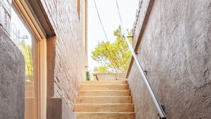 A narrow stairway with a metal handrail, leading up to a window with a view of trees. - Garage, King Bed, and Queen Pullout in Cap Hill. Two Blocks to Metro/Restaurants (Washington)
