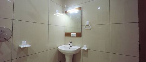 A bathroom with a pedestal sink, a mirror, and a towel rack.