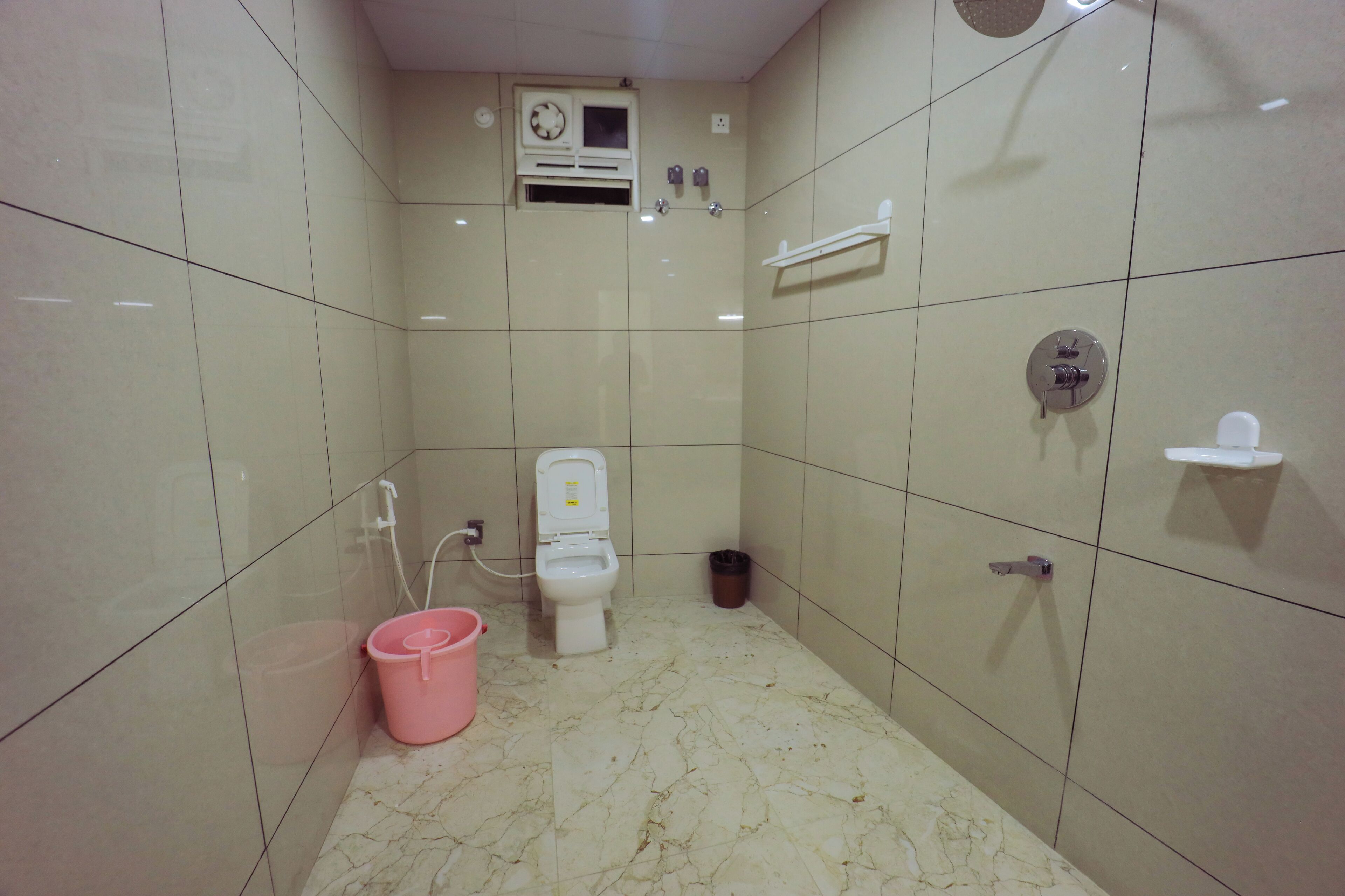 Un baño pequeño con azulejos, un inodoro, una ducha y un lavabo.