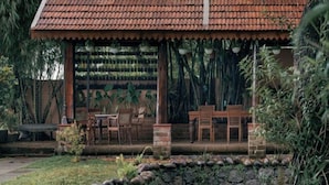 Un bâtiment rustique avec un toit en tuiles, des meubles en bois et un chemin pavé de pierres.