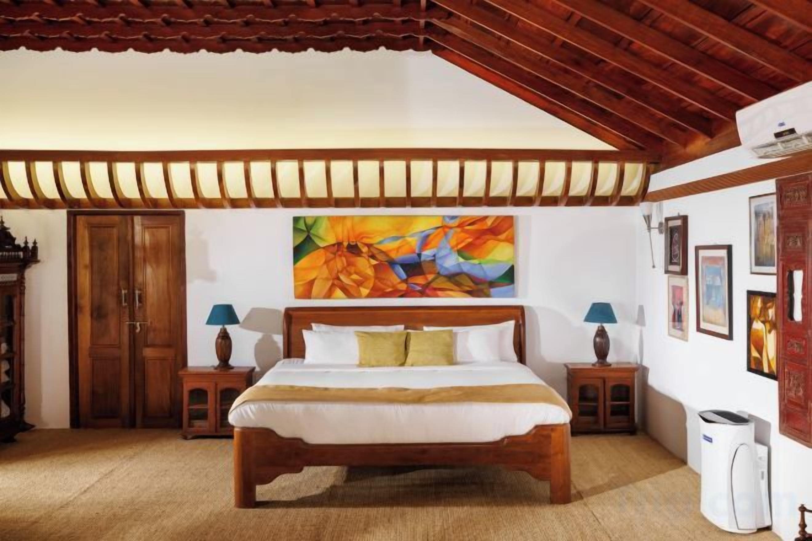 A bedroom with a wooden bed, a painting on the wall, and a ceiling with wooden beams.
