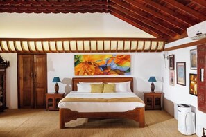 A bedroom with a wooden bed, a painting on the wall, and a ceiling with wooden beams. - BluSalzz Villa - Muhamma, Alleppey - Kerala (Muhamma)