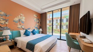 A hotel room with a bed, a desk, a chair, a TV, and a balcony with a view of buildings. - SIREN HOTEL HAI TIEN (Hoang Tien)
