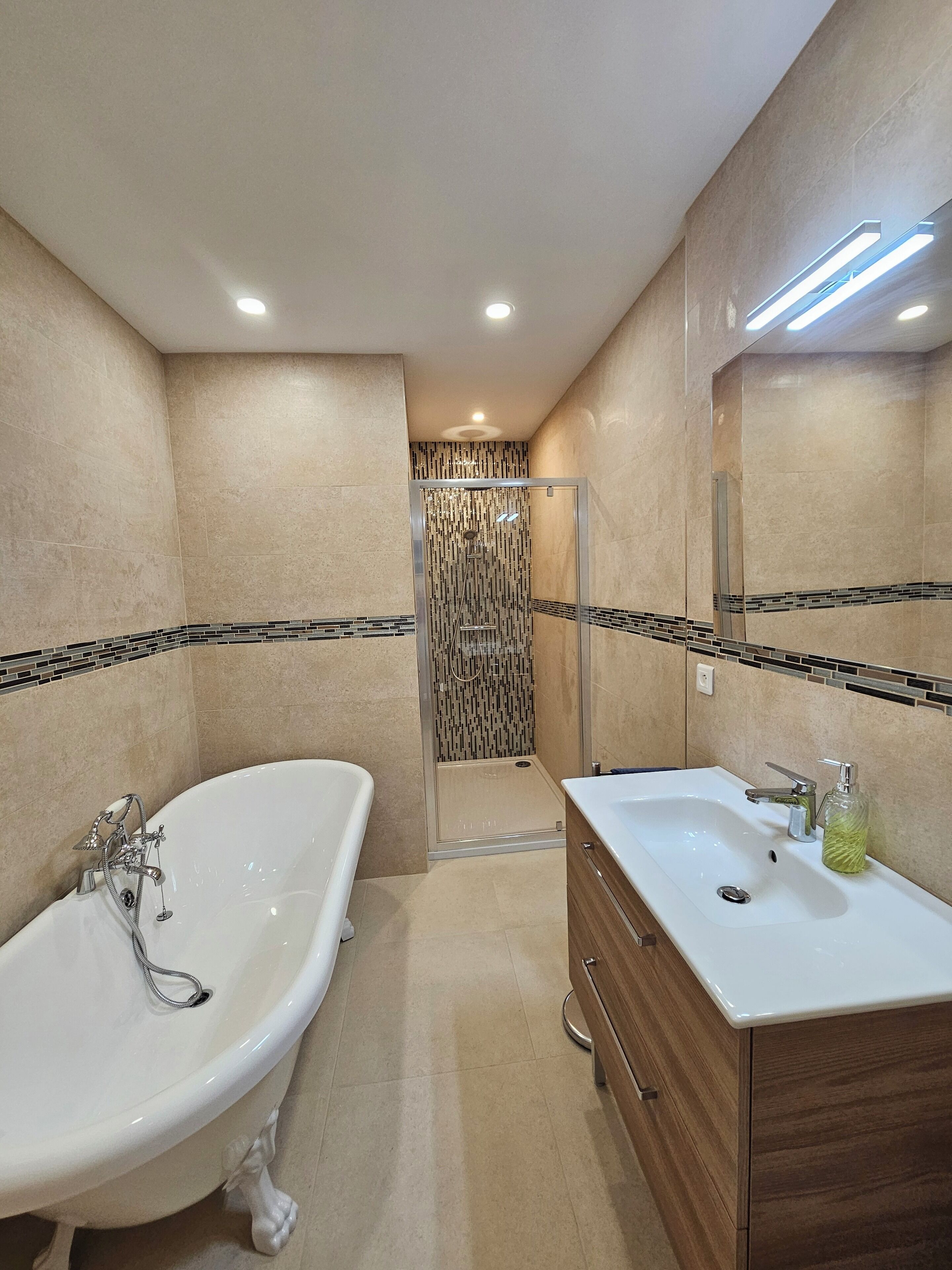 A modern bathroom with a freestanding bathtub, a vanity with a sink, and a shower enclosure.