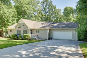 A single-story house with a front porch, a garage, and a well-maintained lawn. - Smith Mountain Lake Home w/ Private Hot Tub & Dock (Moneta)