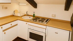 A compact kitchen with a sink, stove, and wooden countertop. - Casa Milano - S. Alessandro 3 - Check-in in via Lupetta 5 (Milan)