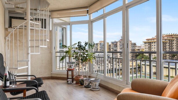 A spacious balcony with a curved staircase, potted plants, and a view of surrounding buildings. - Los Boliches Sunny Apartment - Ref 120 (Fuengirola)