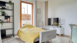 A modern bedroom with a bed, a TV, a desk, and a bookshelf. - Whole Apartment : Apartment in Residence - Montévrain, France (Montévrain)