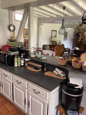 Eine Küche mit schwarzem Arbeitsplatz, weißen Schränken und einer Kaffeemaschine.