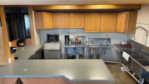 A modern kitchen with wooden cabinets, stainless steel appliances, a granite countertop, and a built-in dishwasher. - Main Street Cabin near Sand Dunes - Fort Garland (Fort Garland)