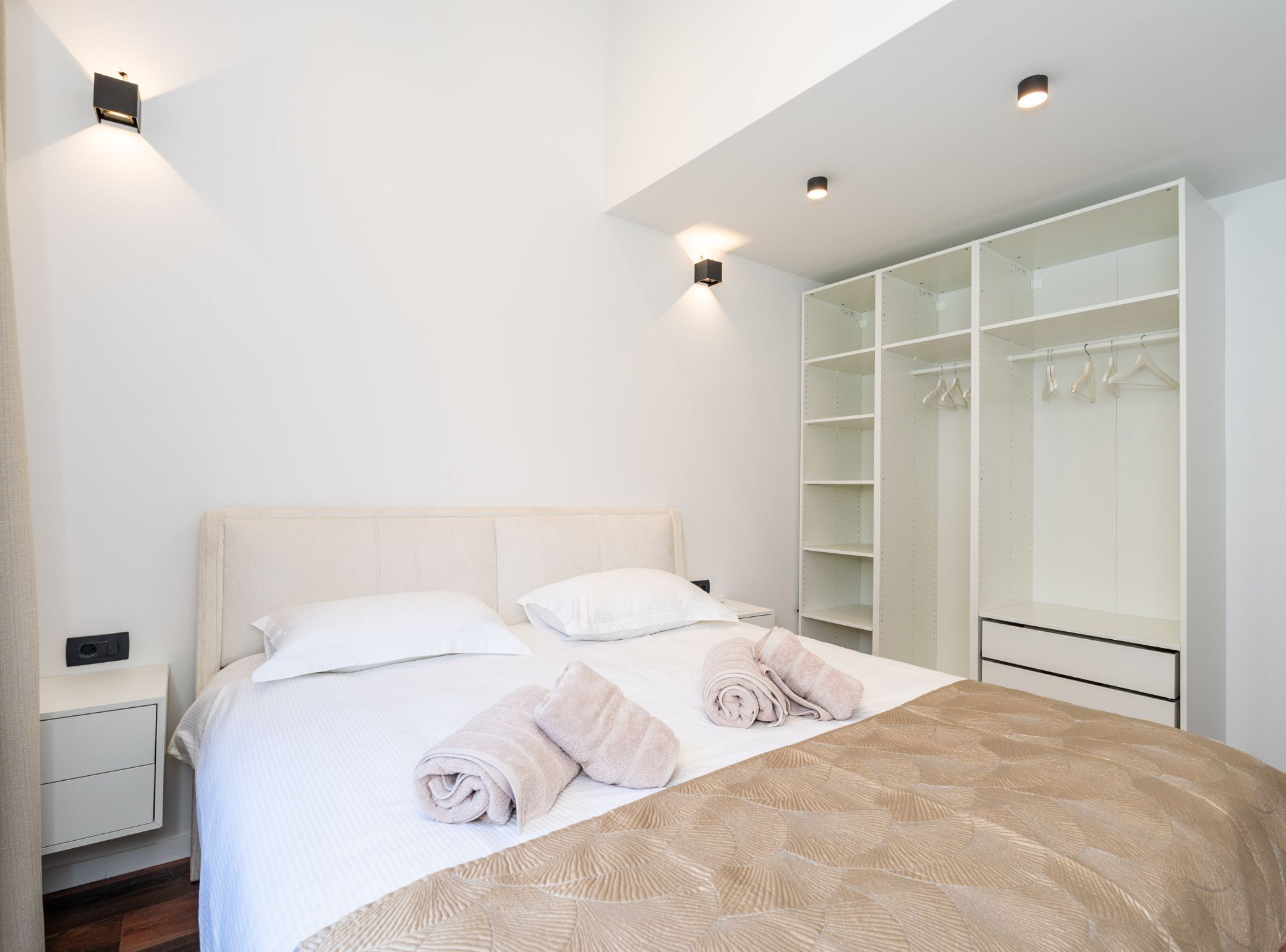 Une chambre à coucher comprenant un lit, une table de chevet, une armoire et un luminaire au plafond.