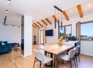 Un comedor moderno con una mesa de madera, sillas blancas y un centro de mesa con frutas.