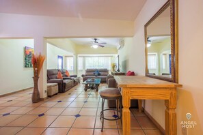 A spacious living room with a sofa set, a coffee table, and a dining table.