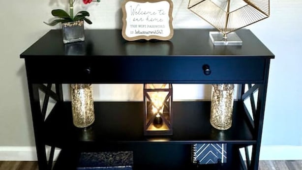 A black console table with a decorative wall panel above it. - Quiet & Cozy in 3BR 2BA (Port Neches)