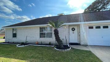 A single-story house with a brick exterior, a front porch, and a well-maintained lawn.