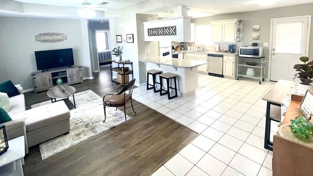 A modern apartment with a living room, dining area, kitchen, and a small balcony.