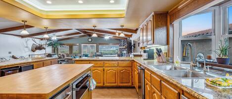 A spacious kitchen with wooden cabinets, stainless steel appliances, and a large island.