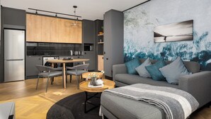 Una sala de estar moderna con un sofá gris, una mesa de centro y un comedor con una mesa y sillas de madera.
