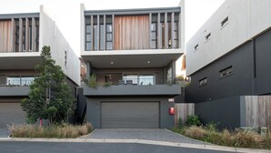 Ein modernes, zweistöckiges Gebäude mit Flachdach, großen Fenstern und einer überdachten Garage.