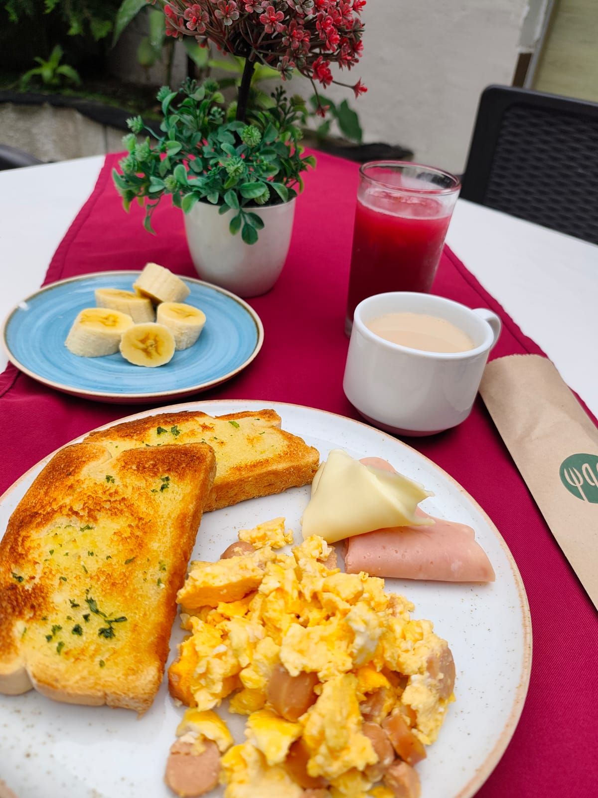 En tallerken med ristet brød, røræg, pølse og et glas rød saftevand.