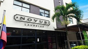 A hotel named 'NOVUS LAURELES' with a modern facade, large windows, and a tiled entrance area. - Novus Laureles (Medellín)