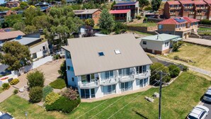 A modern two-story building with a flat roof and large windows. - Parkwood 5 - 2BR Split Level l Spa Bath l BBQ l Central Location l WiFi (Jindabyne)