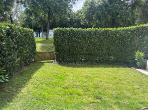 Enjoy a serene garden with a neatly trimmed hedge and lush green lawn.