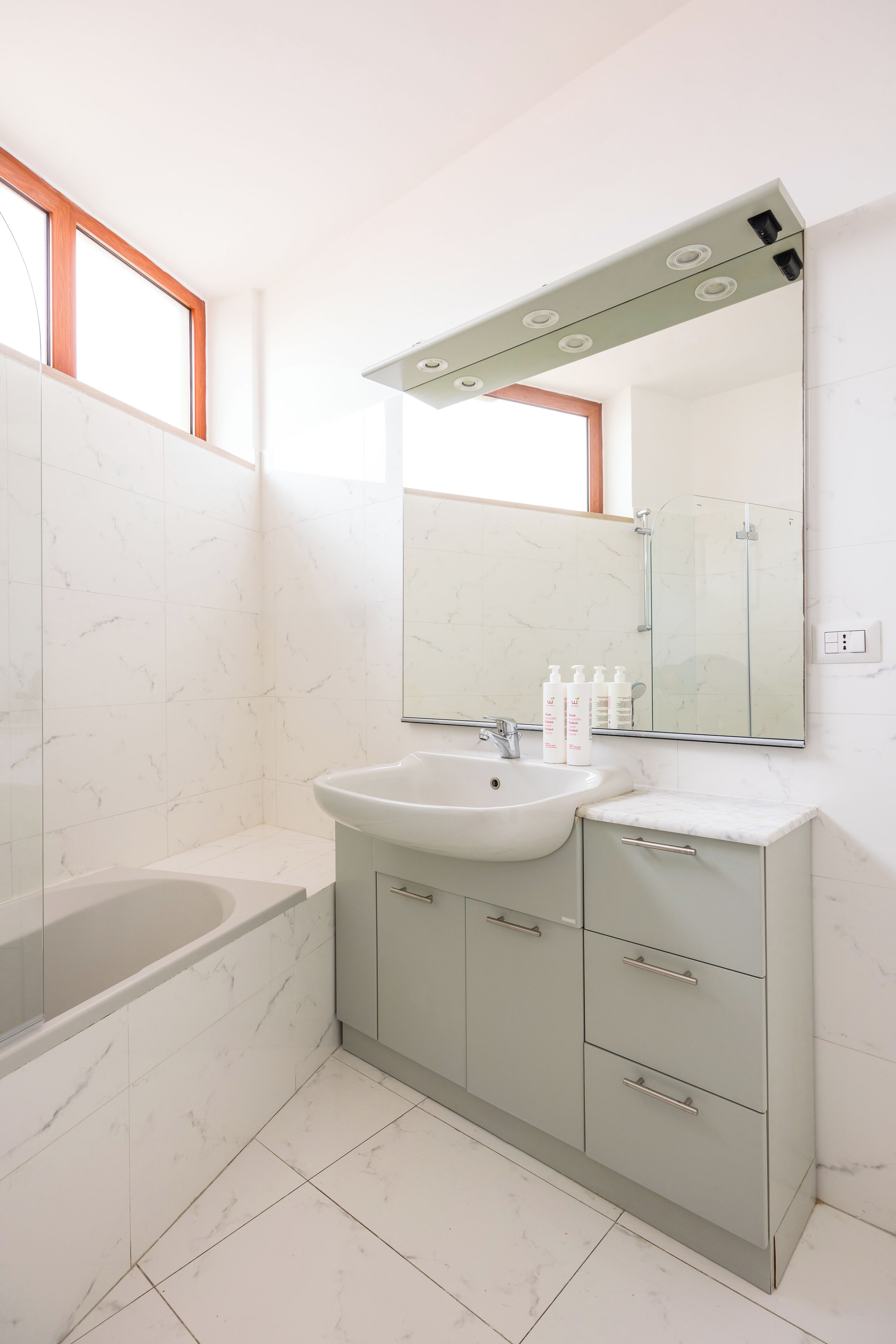 A modern bathroom with a bathtub, sink, and vanity.