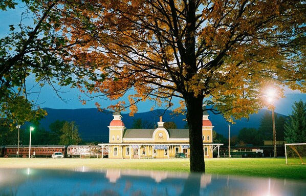 Standing proudly in a serene landscape, this historic building boasts a striking clock tower and tranquil surroundings.