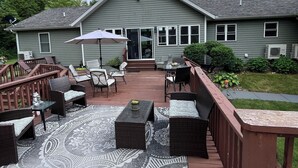 Eine Terrasse mit Gartenmöbeln, einem überdachten Sitzbereich und einem Haus im Hintergrund.