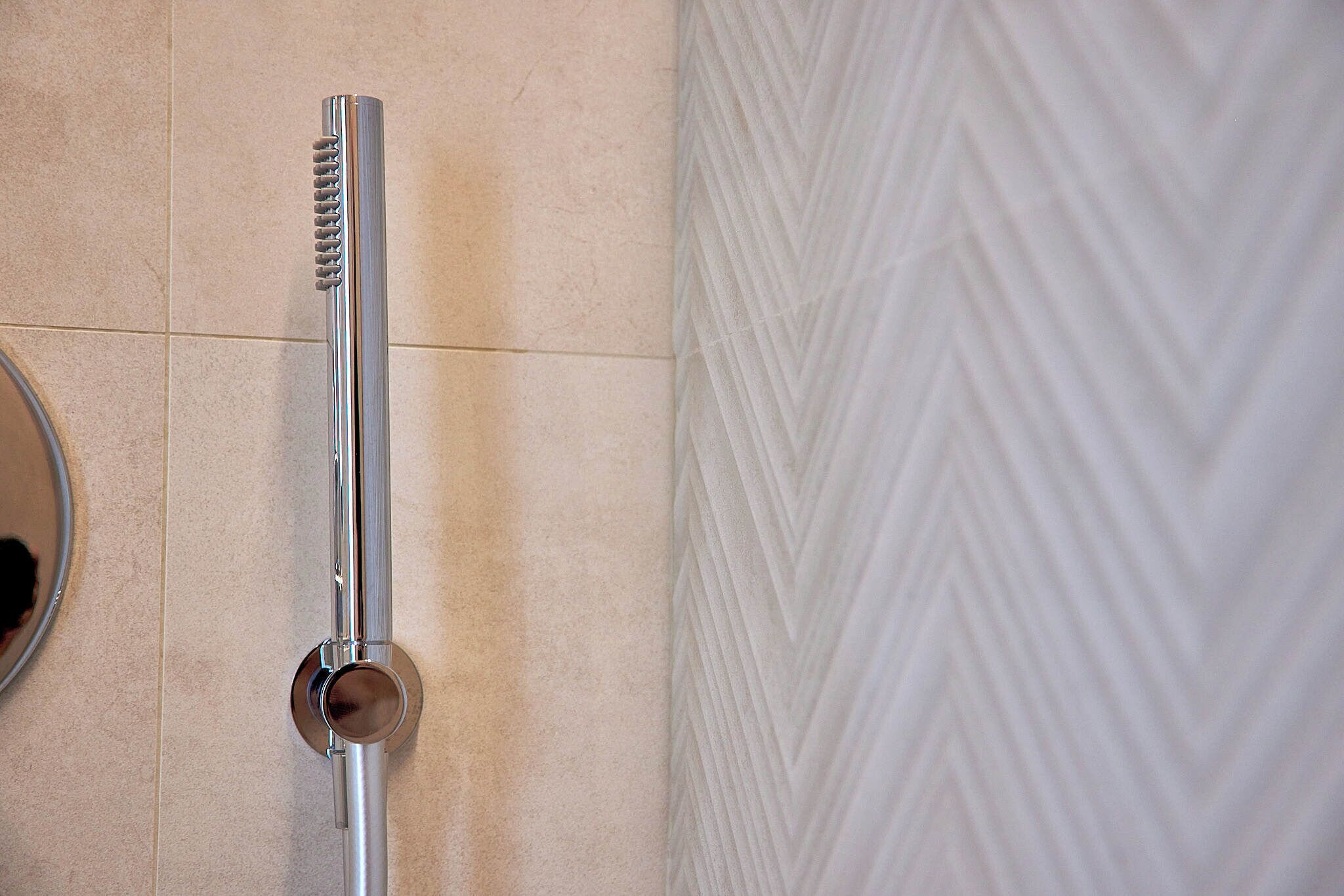 A shower with a chrome finish and a circular handle.