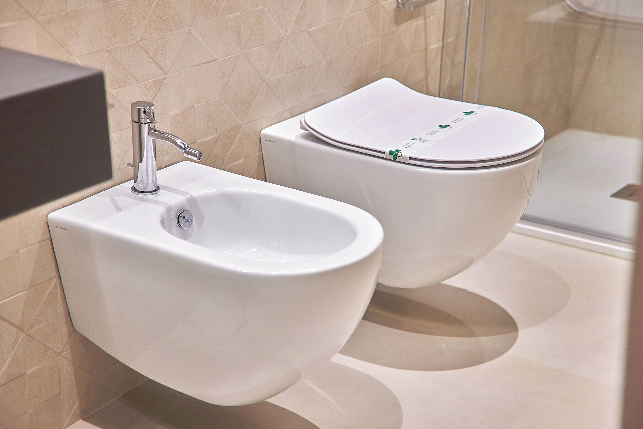 Un baño moderno con bidé, inodoro y lavamanos empotrado.