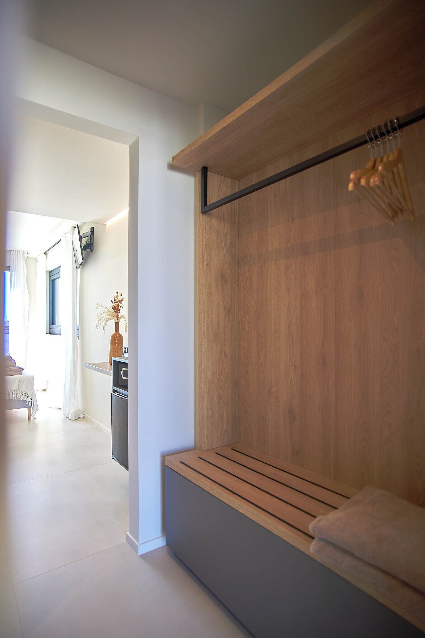 A modern bathroom with a wooden vanity, a towel rack, and a mirror.