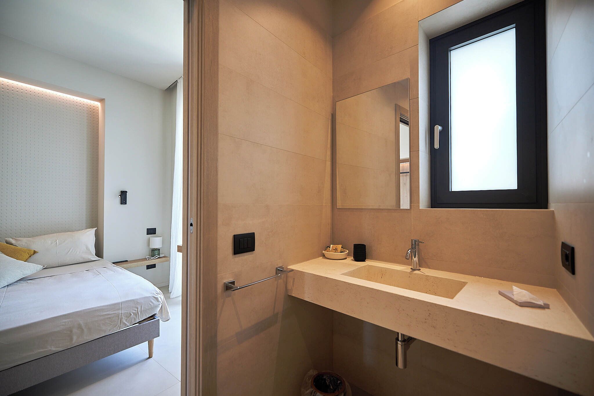 A modern bathroom with a large mirror, a sink, and a shower area.