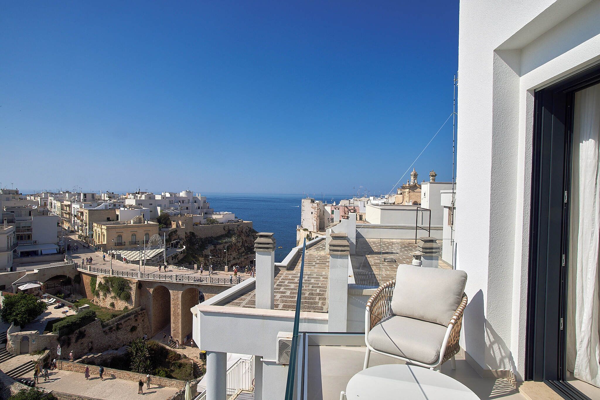 A balcony with a view of the sea and cityscape.