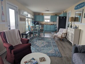 A cozy living room with a red armchair, a blue patterned rug, and a white coffee table.