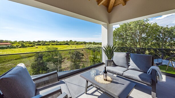 A balcony with a sofa, a glass table, and a bottle of wine. - Villa Antares - Luxurious Vacation Oasis (Štinjan)