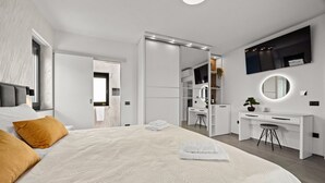 A modern bedroom with a large bed, a walk-in closet, a desk, and a mirror. - Villa Antares - Luxurious Vacation Oasis (Štinjan)