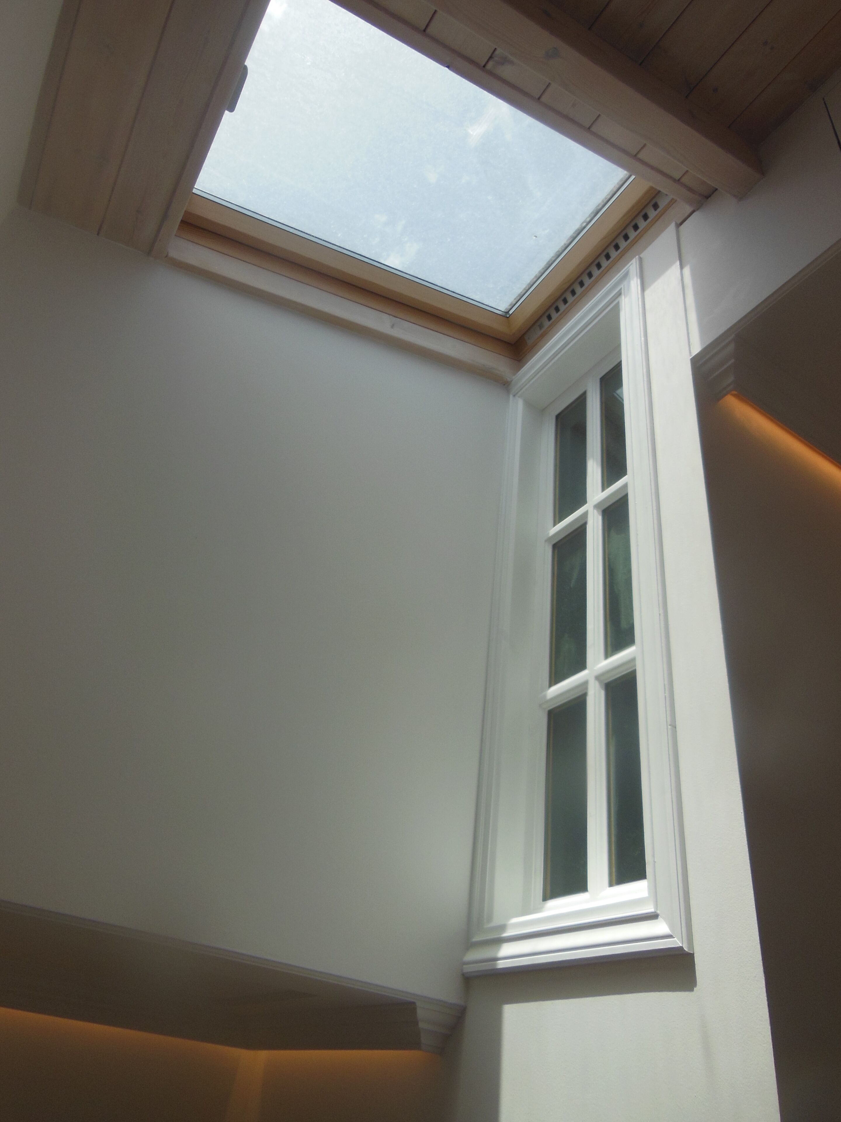 Ein Oberlicht über einem weißen Fenster mit weißem Rahmen.