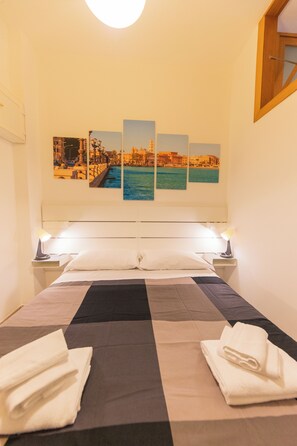 A hotel room with a bed, two nightstands, a headboard, and three framed pictures on the wall.