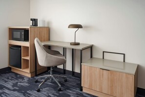 A compact workspace with a desk, chair, and a microwave above a cabinet. - Fairfield By Marriott Inn & Suites East Hartford (East Hartford)