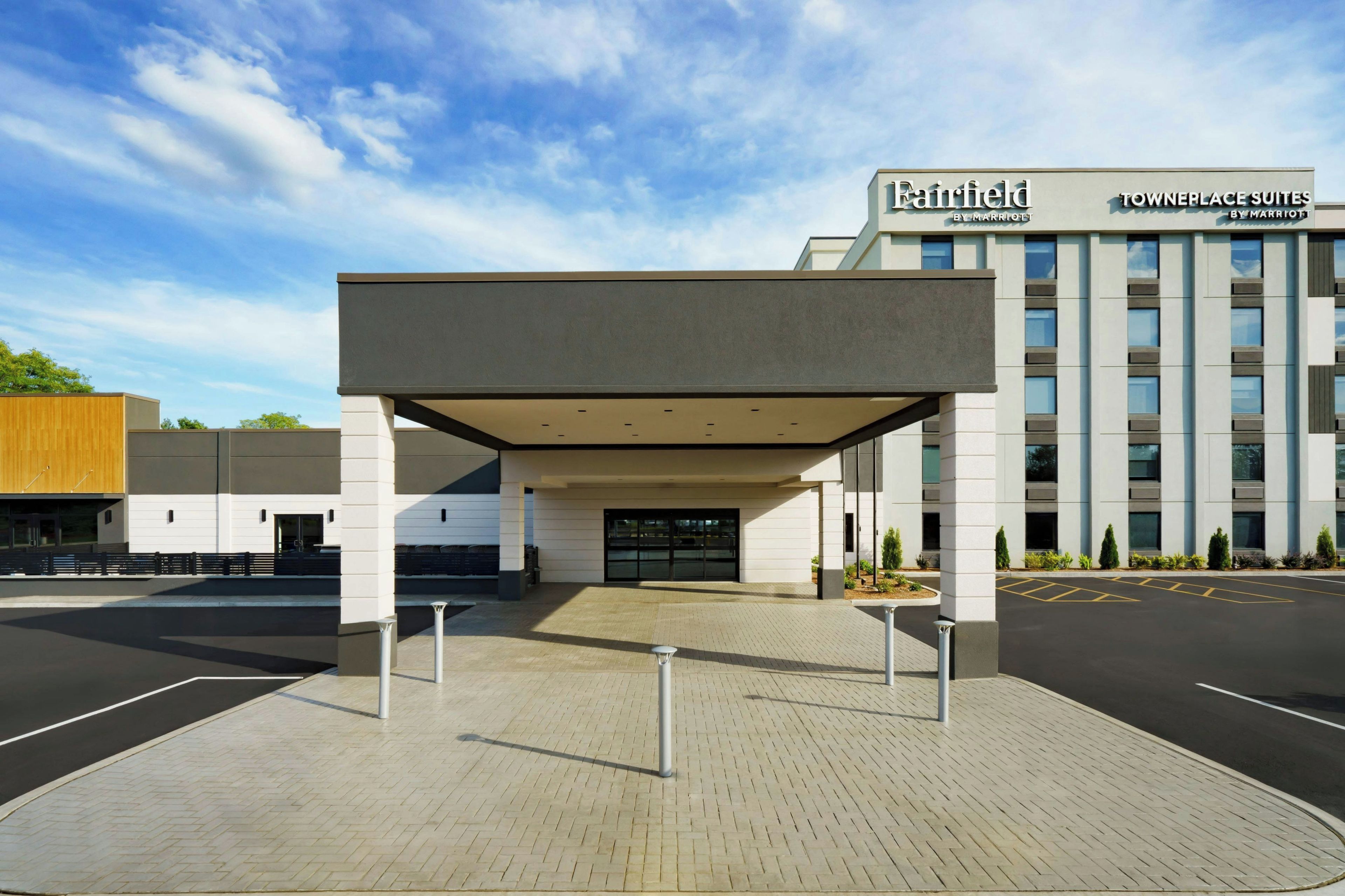 A Fairfield by Marriott hotel entrance with a covered walkway and a parking lot.
