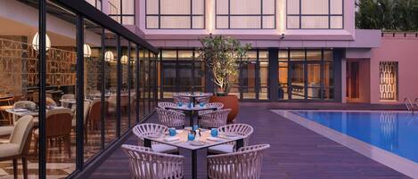 A poolside area with outdoor seating and a view of the building's interior.