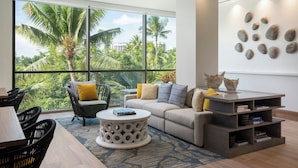 A modern living room with a large window, a sofa, a coffee table, and a bookshelf. - Marriott Vacation Club, Waikiki (Honolulu)