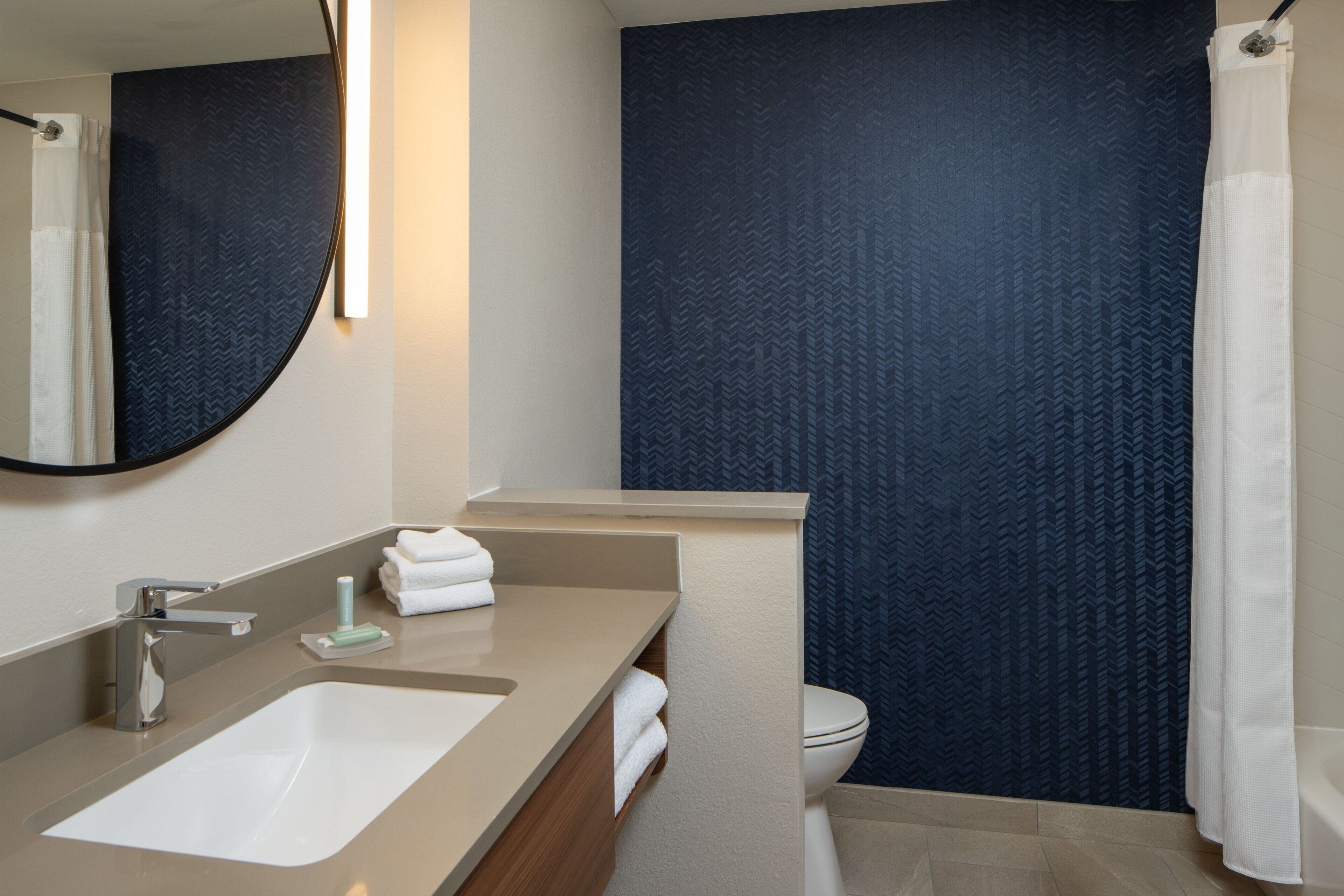 A bathroom with a sink, mirror, and toilet.