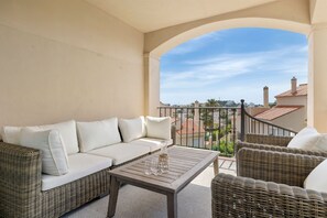 A balcony with a white sofa, wicker furniture, and a clear view of the cityscape. - Riviera del Sol Sunny Rooftop - Ref 45 (Mijas)