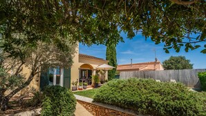 A house with a patio, stone wall, and greenery. - House Doris Hofmann Sa Ràpita with Pool (Sa Rapita)