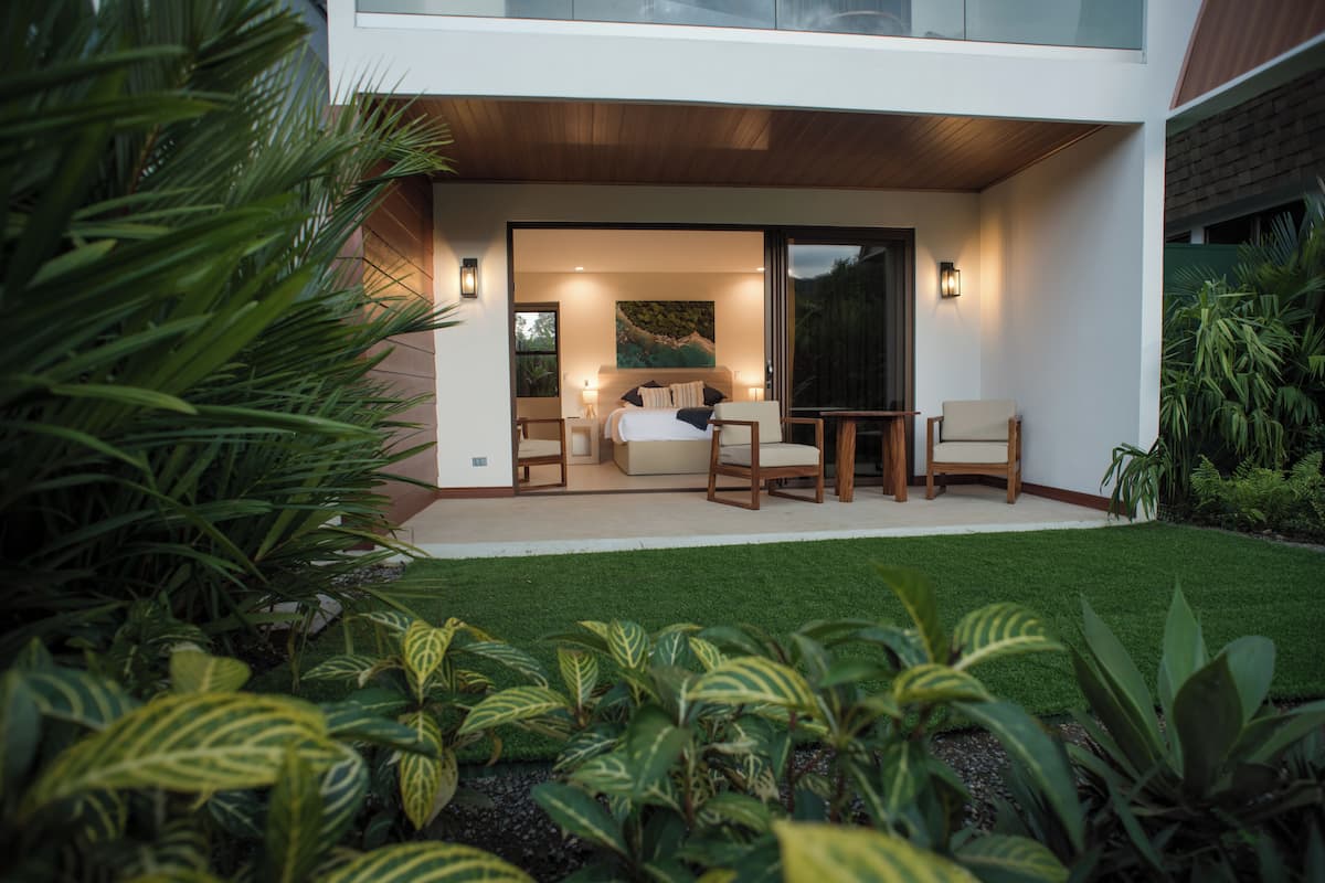 A modern house with a bedroom, a balcony, and a garden.
