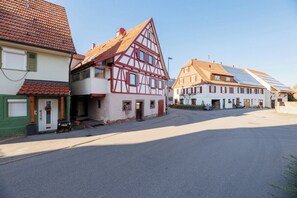 Ein traditionelles Fachwerkhäuschen mit geneigtem Dach und Solaranlage.