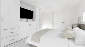 A modern bedroom with a large bed, white wardrobe, and a flat-screen TV mounted on the wall. - Modern A-FRAME cabin in the Ozark Mountains with amazing views! (West Fork)